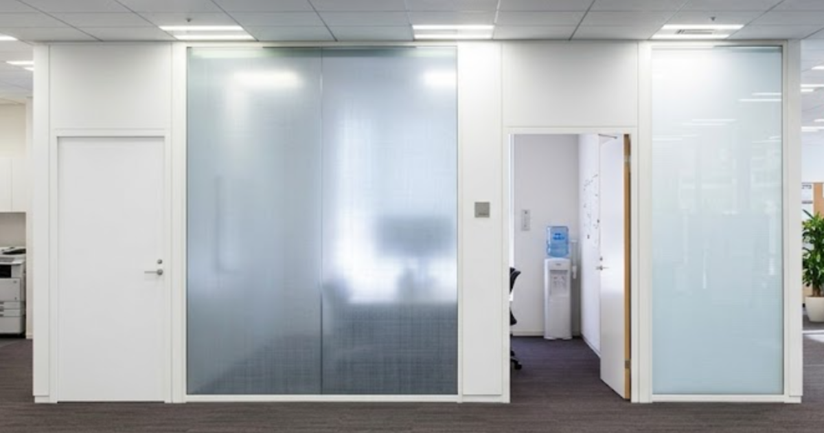Frosted decorative window film applied to glass office partitions, providing privacy while allowing natural light into the workspace.