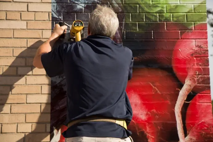 graphic being installed on a brick wall that would need an overlaminate to increase durability